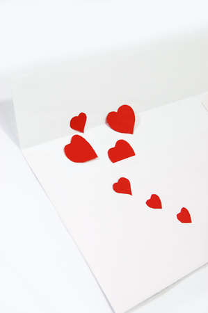white envelope and red hearts over whiteの写真素材