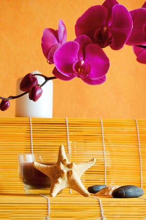 candles, orchids and stones on orange, spa conceptの写真素材