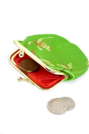 Green purse with some coins in front of itの写真素材