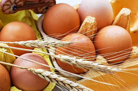Some eggs and several wheat ears in boxの写真素材
