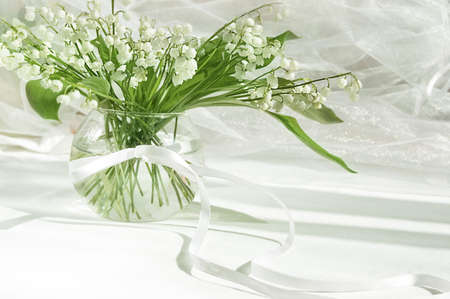Lily of the valley in vase on white fabric backgroundの写真素材