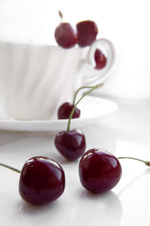 Some cherries in cup over white backgroundの写真素材