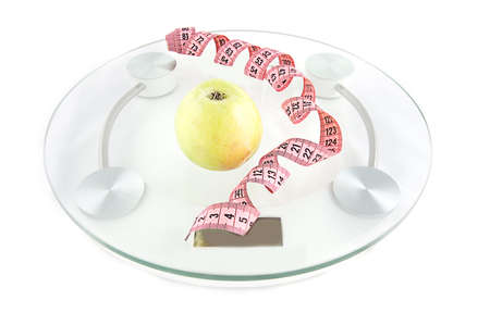 Scale, tape and green apple on white backgroundの写真素材