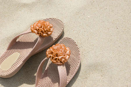 Rabber flip-flops on beach sandの写真素材