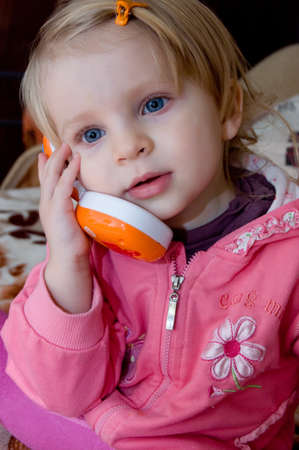 Little girl talking on toy phoneの写真素材