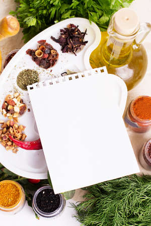 Blank notebook sheet with spices and herbs on the wooden boardの写真素材