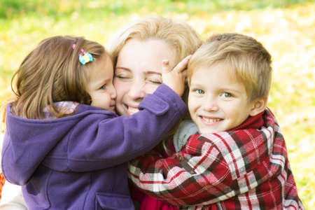 Two children hugging mother, focus on boyの写真素材