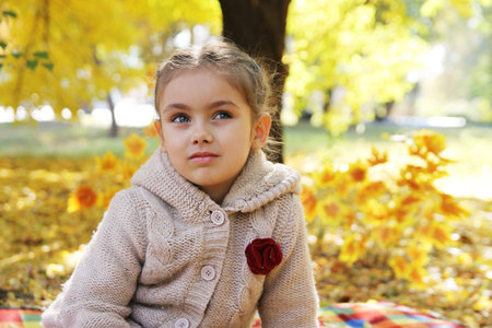 Sad girl looking up under autumn tree