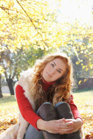 Smiling woman under autumn golden treesの写真素材