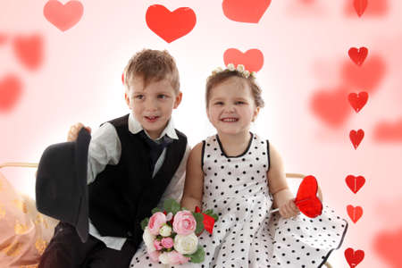 Smiling girl and boy sitting together like lady and gentleman, valentine themeの写真素材