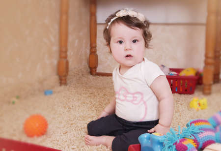 Ten months baby girl playing with toys in nurseryの写真素材