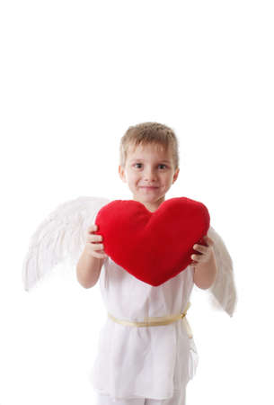 Happy cupid boy with wings holding red plush heart isolatedの写真素材