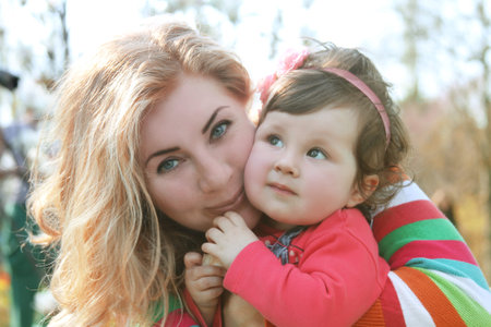 Happy mother and baby girl hugging in spring