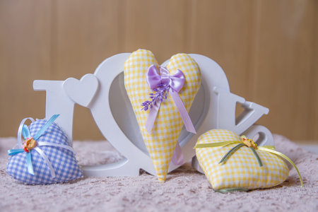 Word love and yellow, blue handmade hearts over lacy back