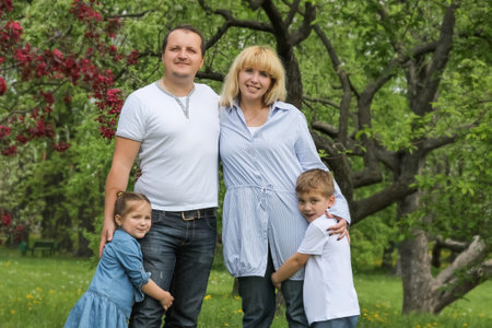 Beautiful family with kids walking in spring garden