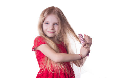 Blonde girl brushing long hair on whiteの写真素材