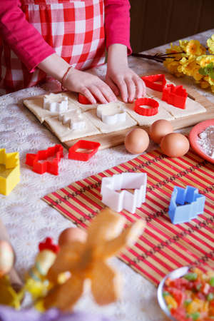 Little girl hands rolling dough at kitchenの写真素材