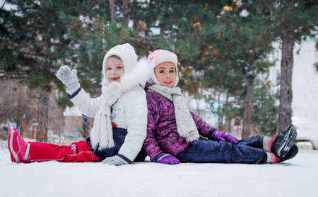 Two cute girls having fun among winter parkの写真素材