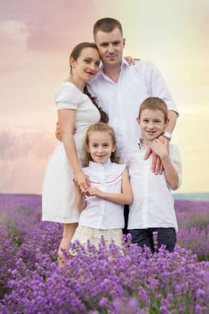 Family of four among lavender field at sunsetの写真素材