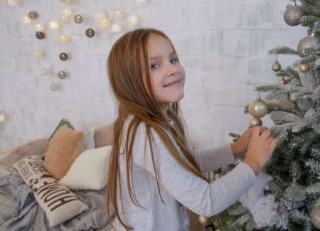 Girl decorating Christmas tree with ballsの写真素材