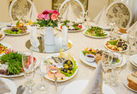 Table set for celebration in classic style with meal in restaurantの写真素材