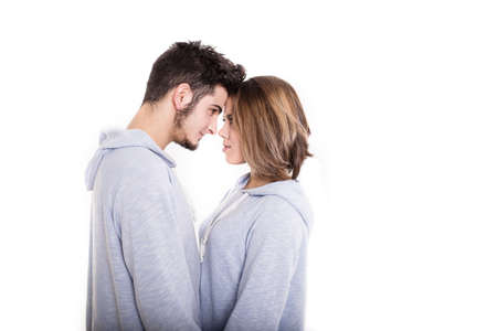 Young couple standing face-to-face in white studioの写真素材