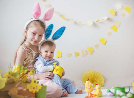 Two cute little children boy and girl wearing bunny ears in Easter decorの写真素材