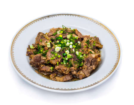 Pork dish with green close-up isolated on whiteの写真素材
