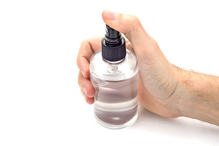 Hand with transparent spray can isolated on white