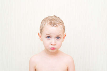 4 year old boy with soapy head on a white background isolatedの写真素材