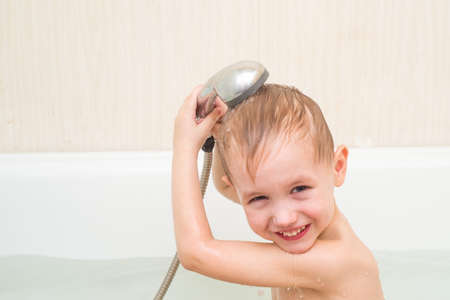 Little 4 year old handsome boy is bathed in the showerの写真素材