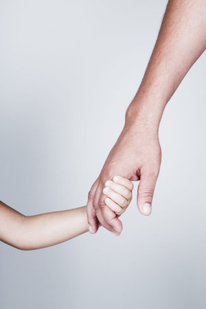 Child holds the hand of father