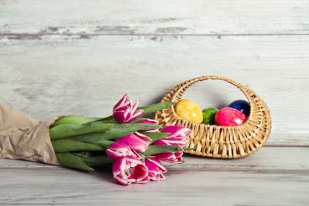 pink tulips and basket with eggsの写真素材