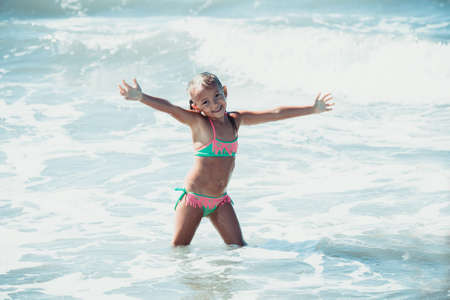 Happy little girl in sea waterの写真素材