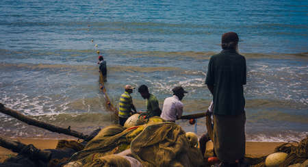 GALLE, SRI LANKA - MARCH 03 2017: Traditional fishing technique, used by local fisherman, at beaches of Sri Lanka. Fishermen pull the seine net out of the sea.のeditorial素材