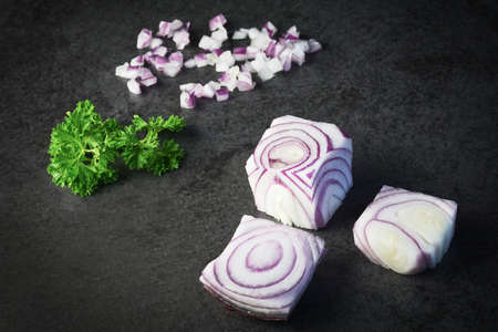 a cube onion with parsley on black backgroundの写真素材
