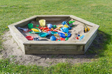 sand box in the garden with a lot of children's toysの写真素材