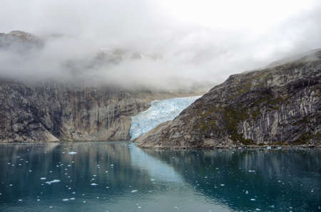 glacier in the Prince Christian Sound, Greenland, black mood with many cloudsの写真素材