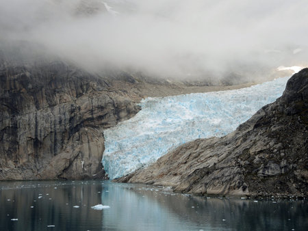 Glacier in the Prince Christian Sound, Greenland, black mood with many cloudsの写真素材