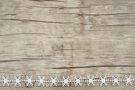 Horizontal photo with a set of wooden snowcrystals at the bottom picture, wooden background with copy spaceの写真素材