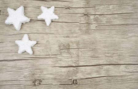 Three decorative snow stars in the left corner on wooden background with copy spaceの写真素材