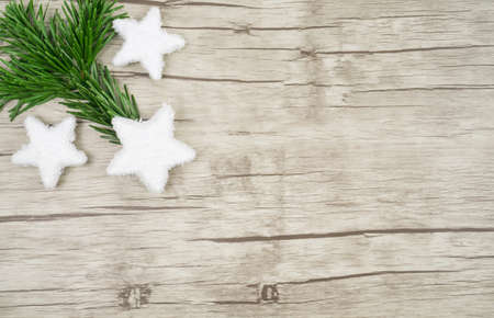 Three decorative snow stars with fir branch in the left corner on wooden background with copy spaceの写真素材