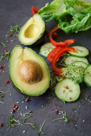 A halved avocado with kernel, sliced ??pepperの写真素材