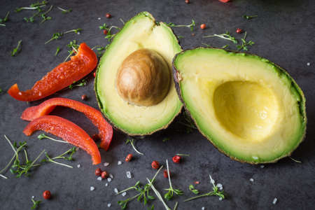 A halved avocado with kernel, sliced ??pepperの写真素材