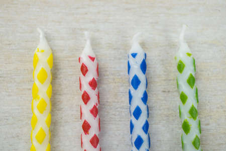 Four colorful candles on wooden backgroundの写真素材
