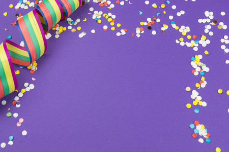 Colorful streamers and confetti, ultra violet background