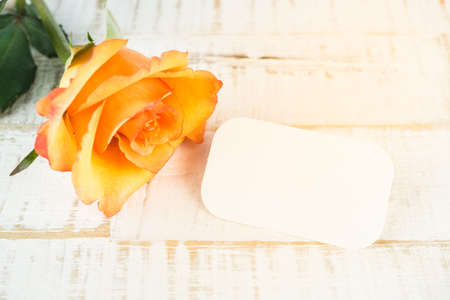 Orange rose with blank label on wooden backgroundの写真素材