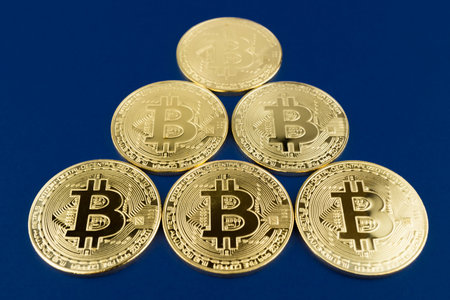 Bitcoins in pyramid on blue background