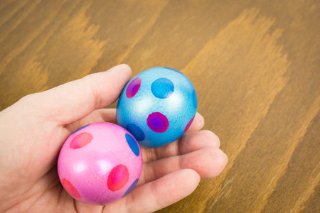 Two colorful easter eggs holding in hand
