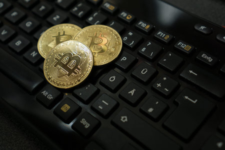 Three bitcoins on computer keyboard